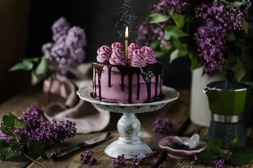 Purple celebration cake with chocolate drip and floral styling
